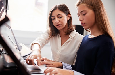 piano teacher and student
        sitting at a piano